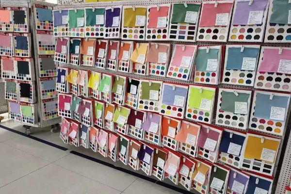 A hand holding a small fabric swatch card